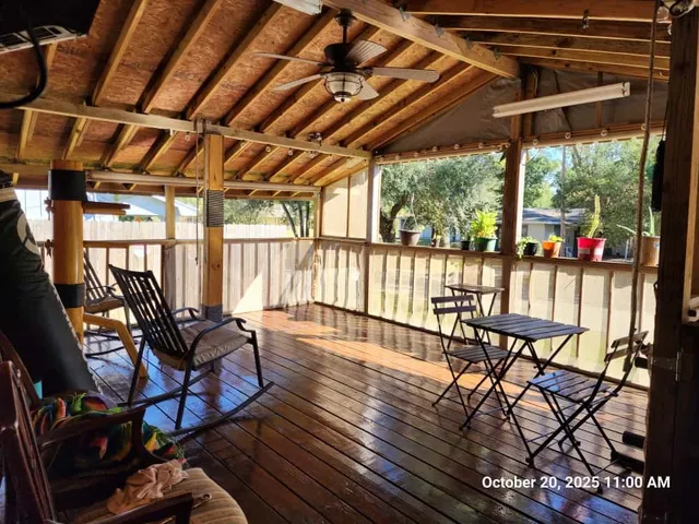 a view of a patio with table and chairs and wooden floor