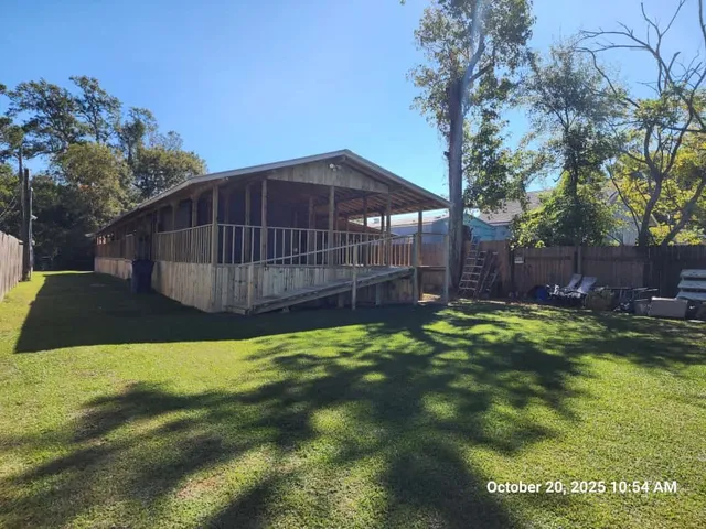a white house that has a big yard with wooden fence