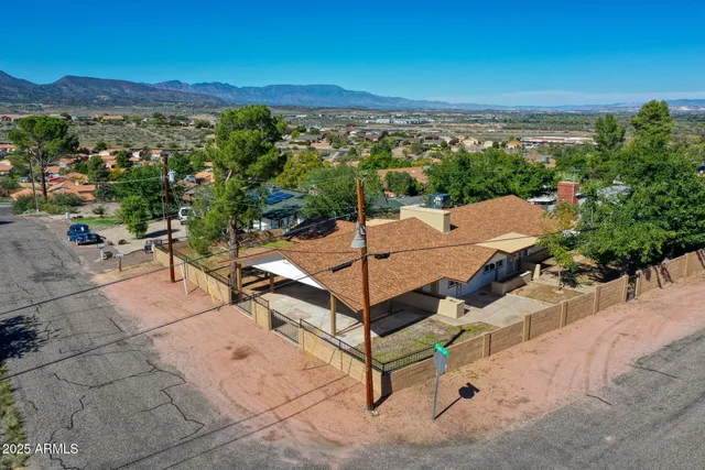 an aerial view of a house with yard and mountain view in back