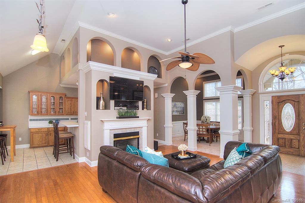 29023 Beaver Run Tega Cay, SC 29708 - Photo 5 of 24 a living room with furniture a fireplace and a chandelier