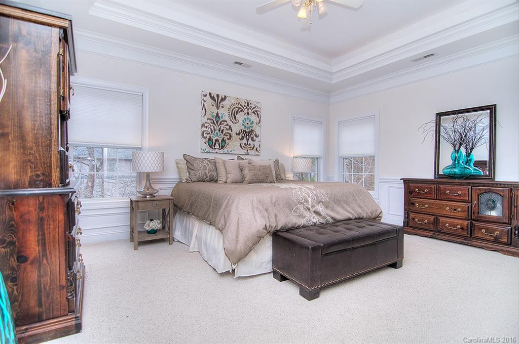 29023 Beaver Run Tega Cay, SC 29708 - Photo 9 of 24 a spacious bedroom with a bed a couch and a painting on the wall