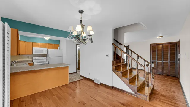 a view of a livingroom with wooden floor and stairs