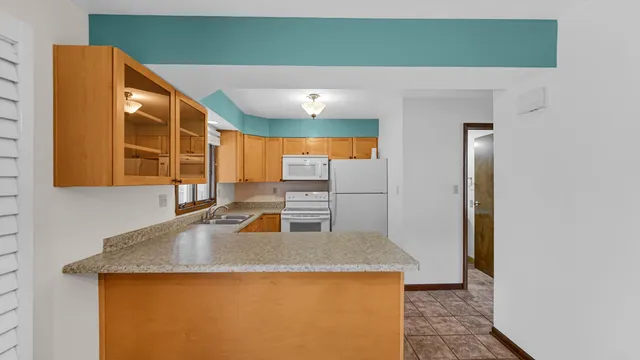 a kitchen with a sink a refrigerator and cabinets