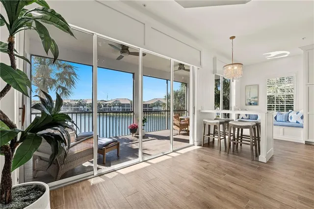 a living room with furniture floor to ceiling window and wooden floor