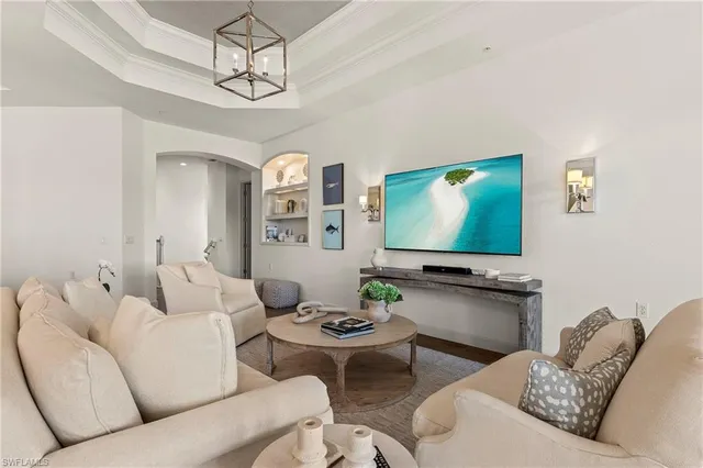 a living room with furniture kitchen view and a flat screen tv