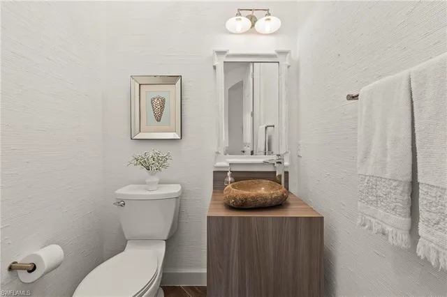 a bathroom with a toilet a sink and mirror