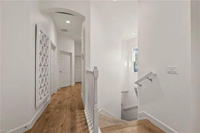 a view of a hallway with wooden floor and staircase