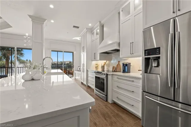 a kitchen with white cabinets and stainless steel appliances
