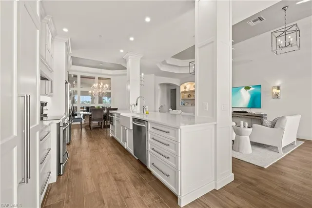a open kitchen with white cabinets and stainless steel appliances