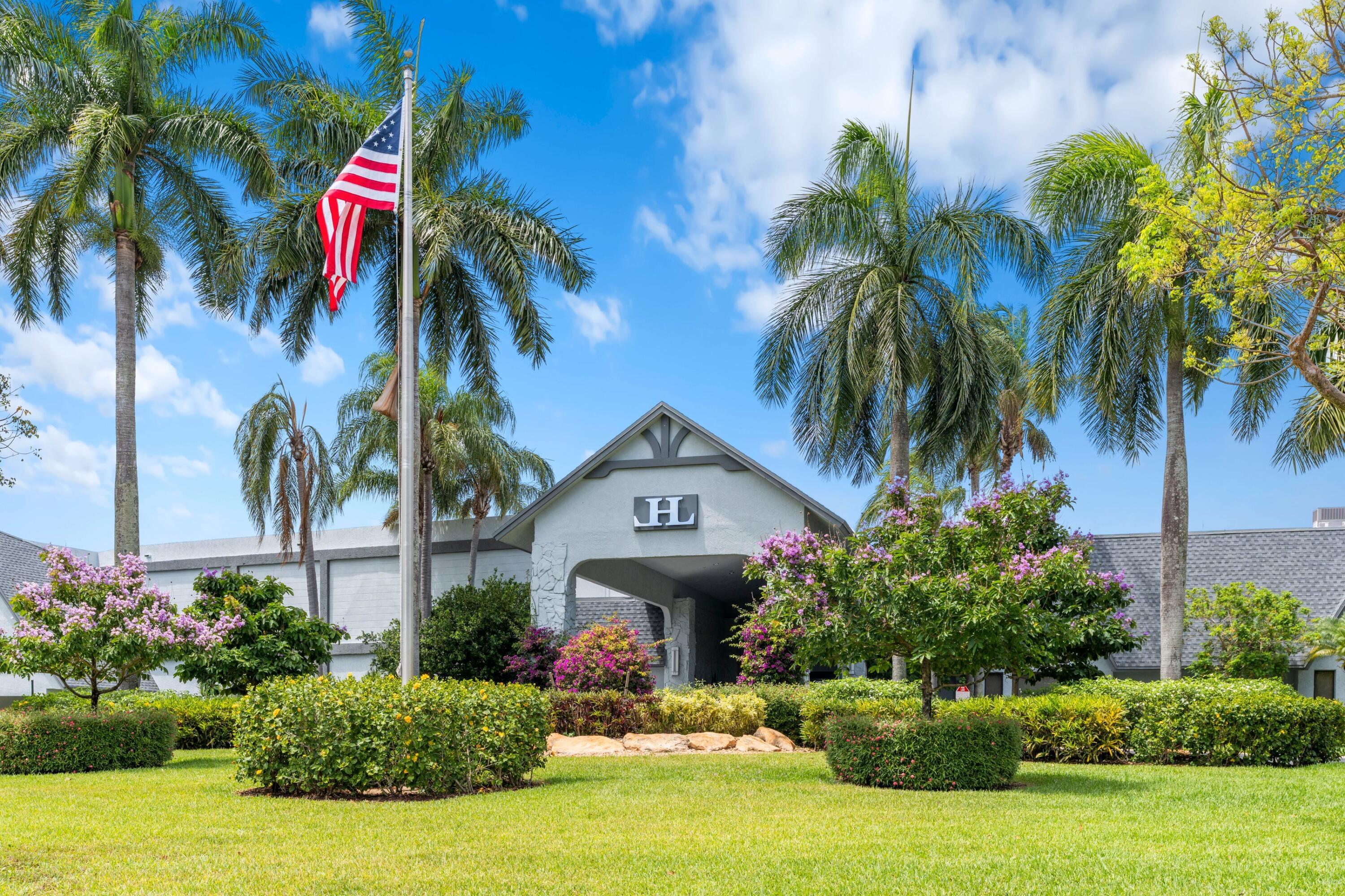 14360 Strathmore Lane, Unit 404 Delray Beach, FL 33446 - Photo 21 of 42 a front view of multi story residential apartment building with yard and sign board