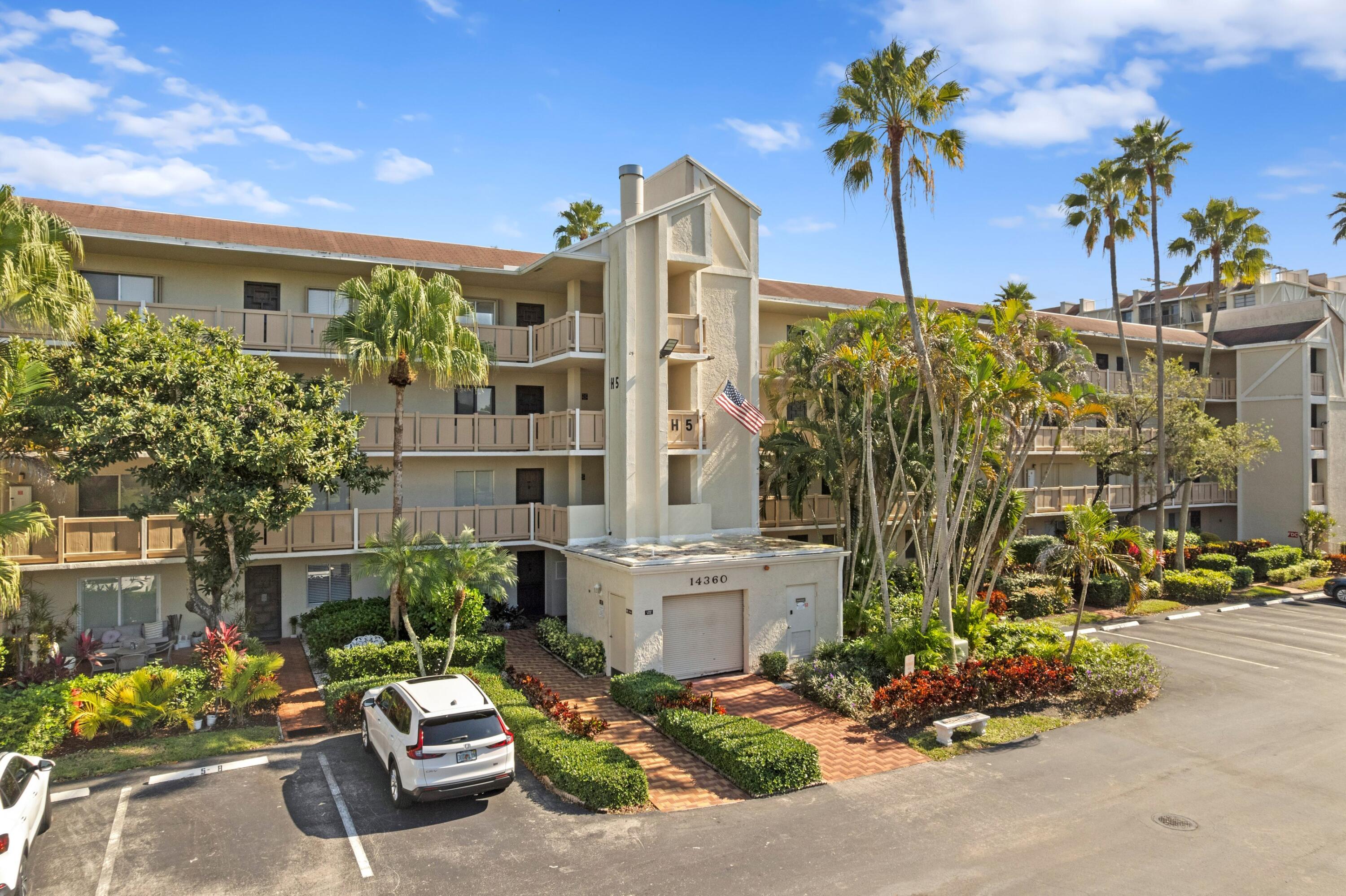 14360 Strathmore Lane, Unit 404 Delray Beach, FL 33446 - Photo 27 of 42 a front view of a building with outdoor space and parking