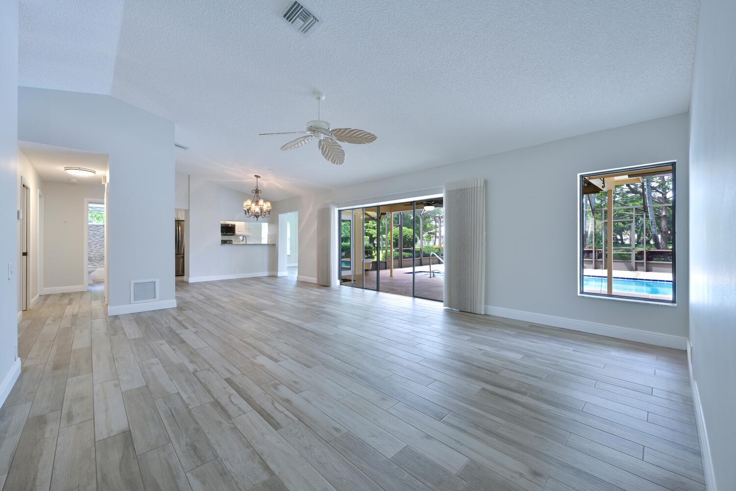166 Bayberry Circle Jupiter, FL 33458 - Photo 11 of 37 an empty room with wooden floor and windows