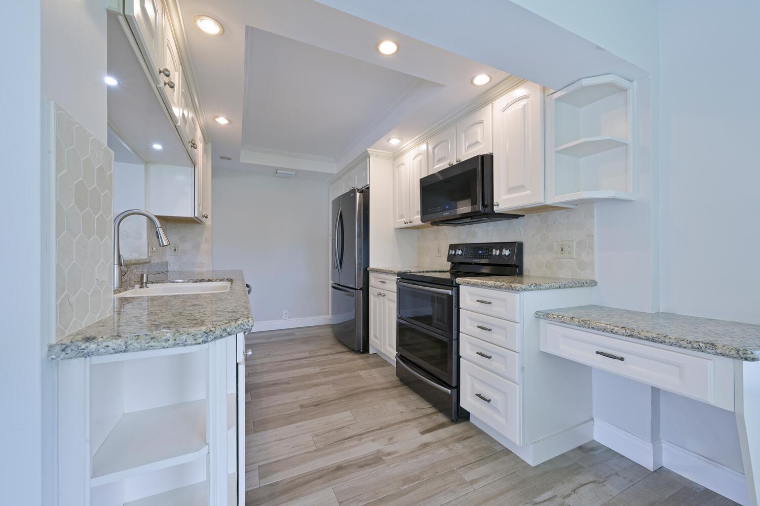 166 Bayberry Circle Jupiter, FL 33458 - Photo 16 of 37 a kitchen with stainless steel appliances granite countertop a stove top oven a sink and a granite counter tops