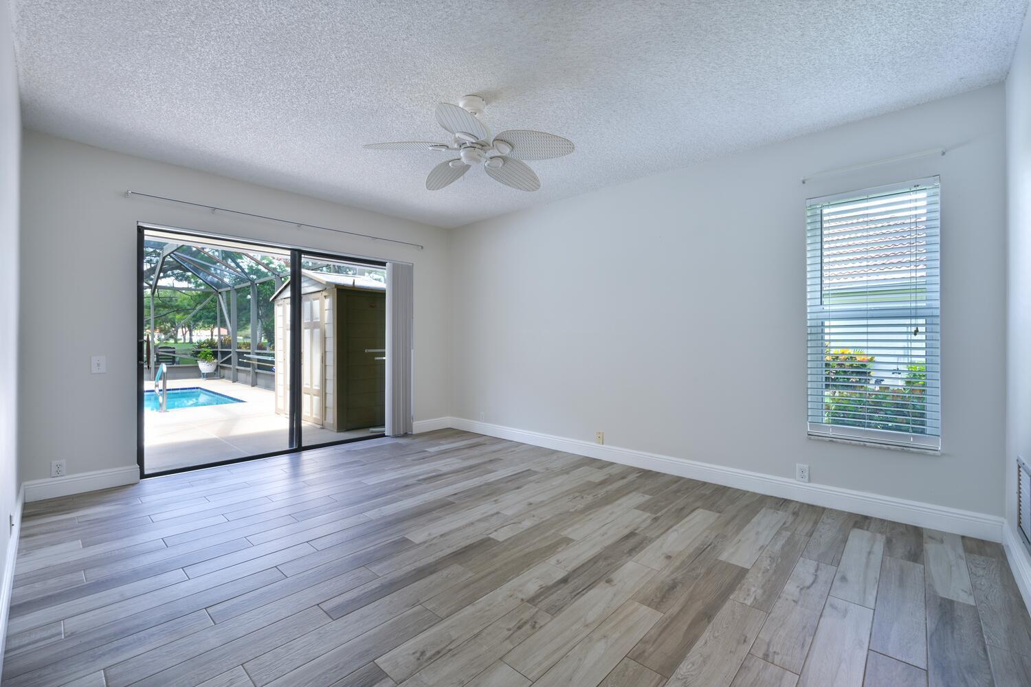 166 Bayberry Circle Jupiter, FL 33458 - Photo 17 of 37 a view of an empty room with wooden floor and a window