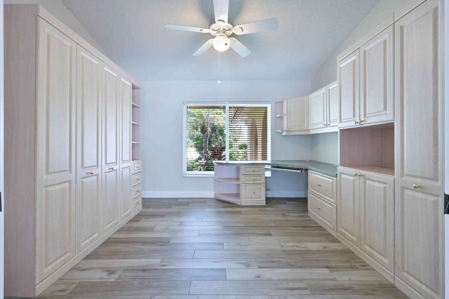 166 Bayberry Circle Jupiter, FL 33458 - Photo 23 of 37 a kitchen with kitchen island white cabinets and wooden floors
