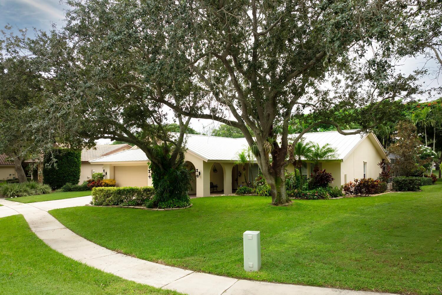 166 Bayberry Circle Jupiter, FL 33458 - Photo 4 of 37 a front view of a house with garden