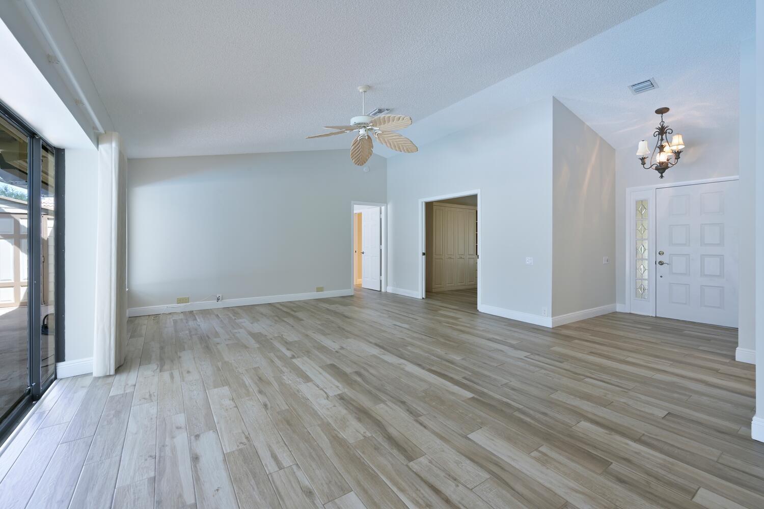 166 Bayberry Circle Jupiter, FL 33458 - Photo 9 of 37 wooden floor in an empty room with a window