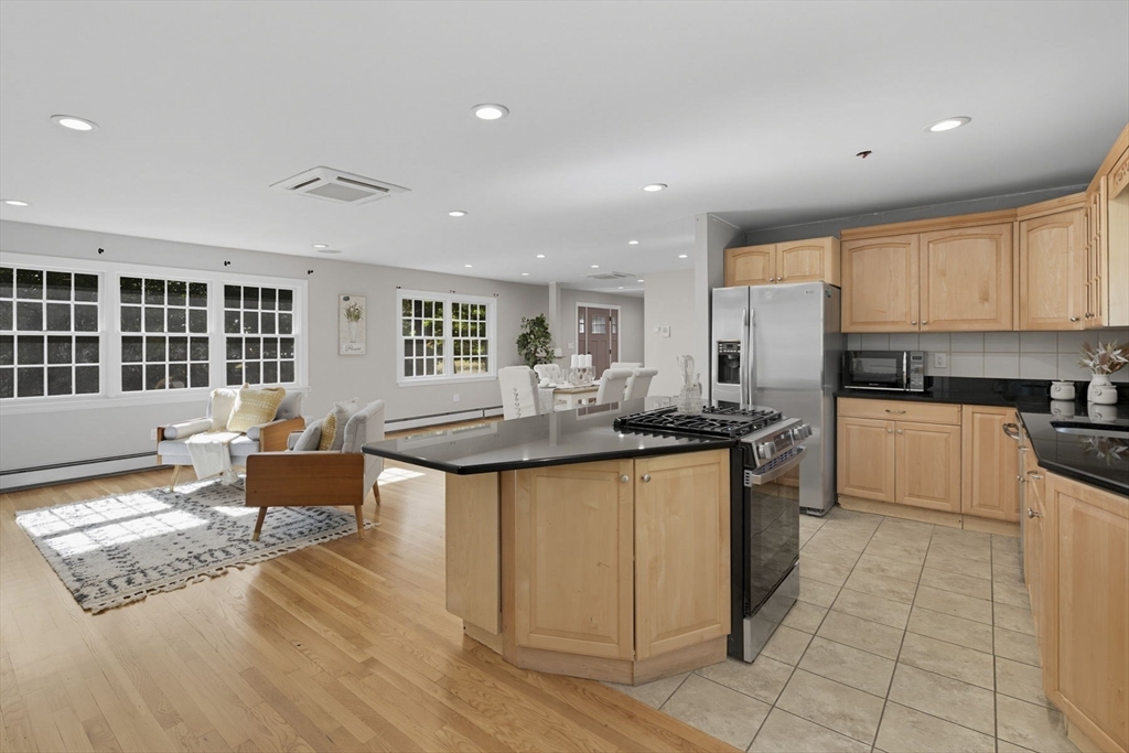 5 Charles Street Georgetown, MA 01833 - Photo 13 of 36 a kitchen with stainless steel appliances granite countertop a stove top oven a sink dishwasher and a refrigerator with wooden floor