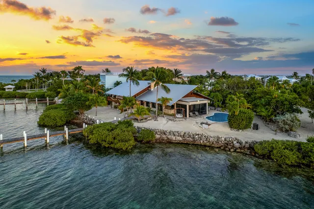 an aerial view of a house with a garden and lake view