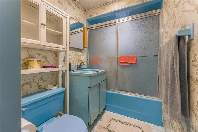 a bathroom with a sink a toilet and shower