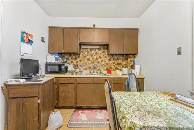 a kitchen with a sink cabinets and wooden floor