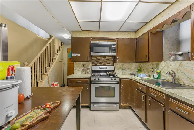 a kitchen with a sink appliances cabinets and furniture