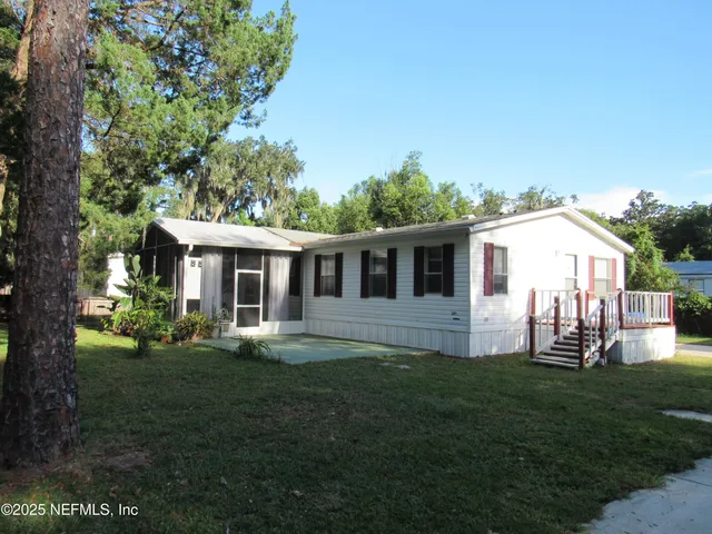a front view of house with a garden and trees