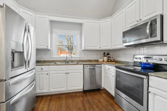 a kitchen with stainless steel appliances granite countertop a stove a sink and a microwave