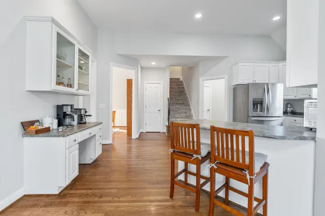 a kitchen with stainless steel appliances kitchen island granite countertop a table and chairs in it