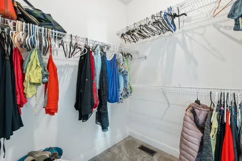 a view of walk in closet with clothes