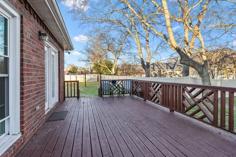 a balcony with wooden floor and fence