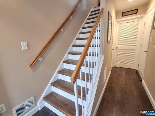 a view of staircase with wooden floor and white walls