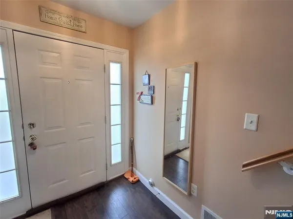 an empty room with wooden floor and entrance