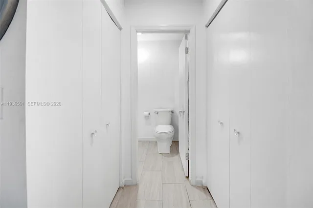 a bedroom with a bed a chair and a large window