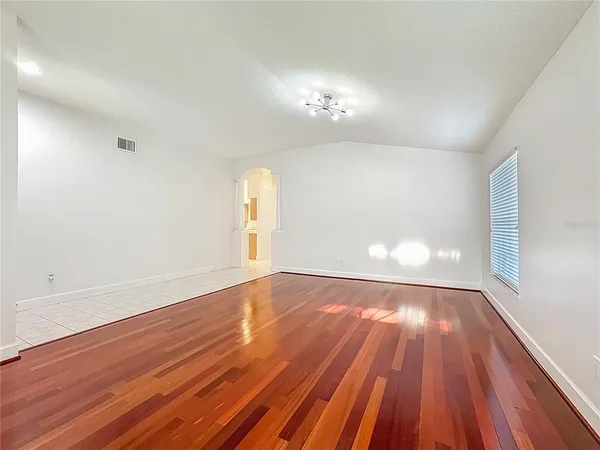 a view of empty room with wooden floor