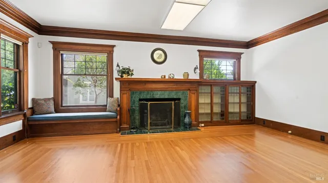 a view of an empty room with a fireplace and a window