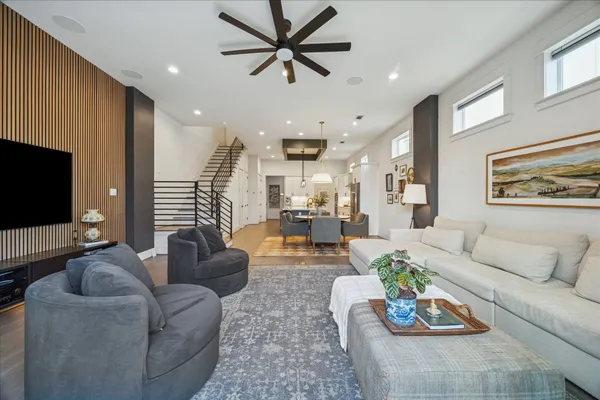 a living room with furniture kitchen view and a flat screen tv