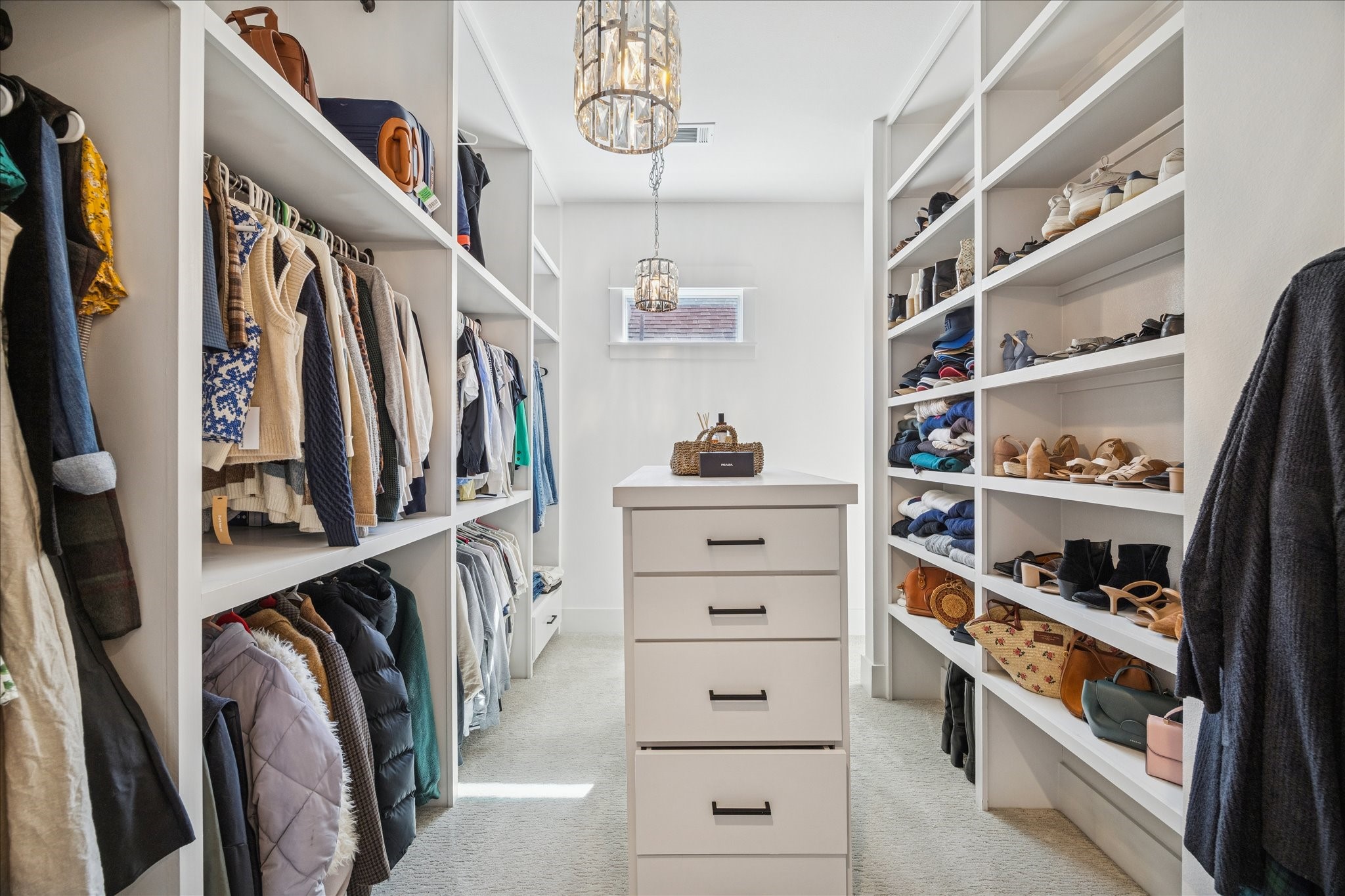 1311 Laird Street Houston, TX 77008 - Photo 26 of 28 Discover your primary suite dream closet featuring floor-to-ceiling shelving, double hanging rods, two chandeliers and a center packing island.
