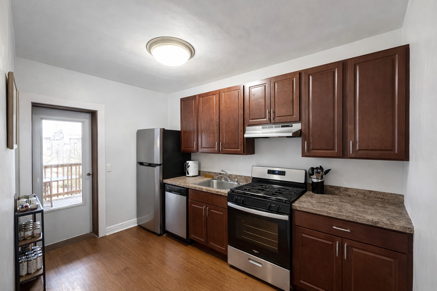 2461 North Clark Street, Unit 2 Chicago, IL 60614 - Photo 4 of 9 a kitchen with granite countertop wooden cabinets and a stove top oven