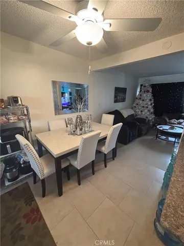 a view of a livingroom and a dining room with furniture wooden floor and chandelier