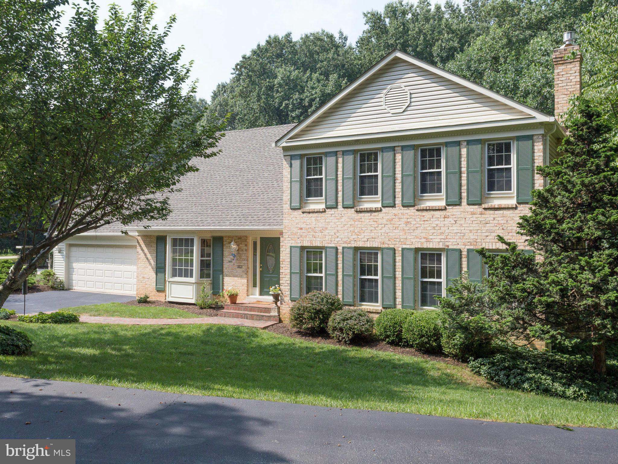 a front view of a house with a yard and trees