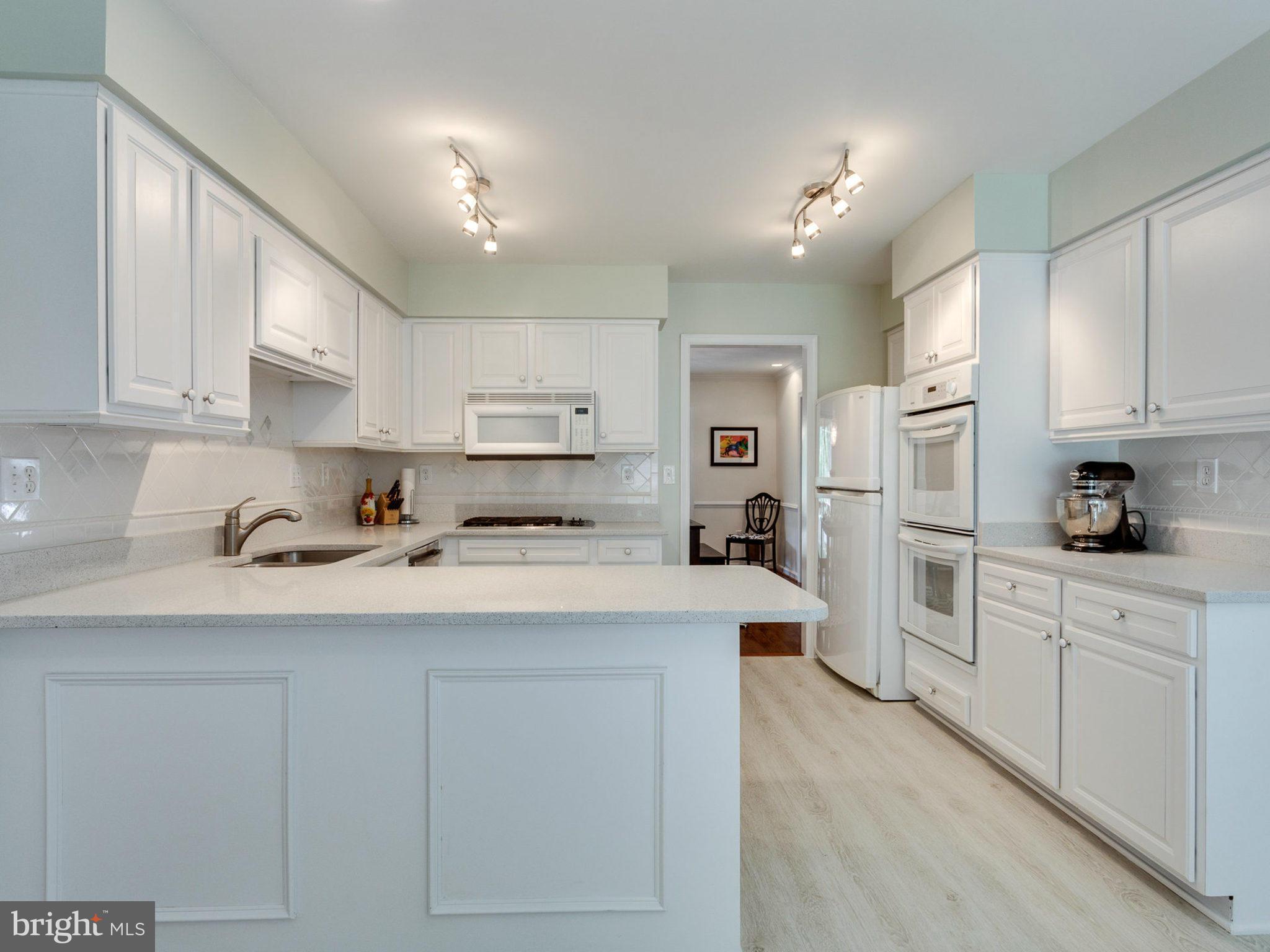 1802 Batten Hollow Road Vienna, VA 22182 - Photo 10 of 30 a kitchen with white cabinets and stainless steel appliances