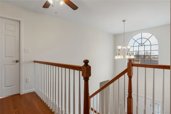 a view of staircase with railing and chandelier