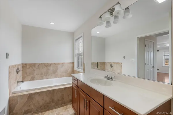 a bathroom with a sink a bathtub and a mirror