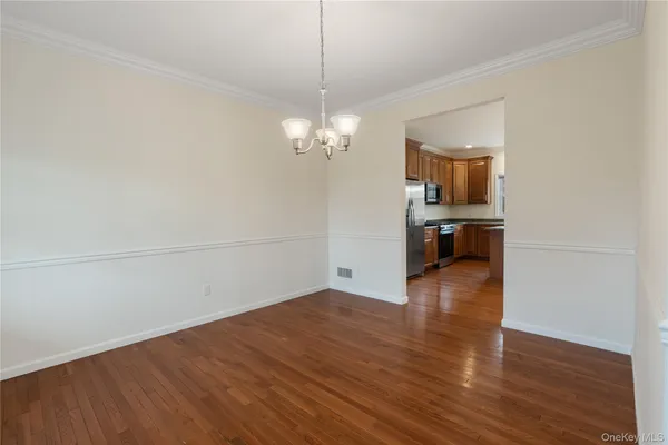 a view of a room with wooden floor and a ceiling fan