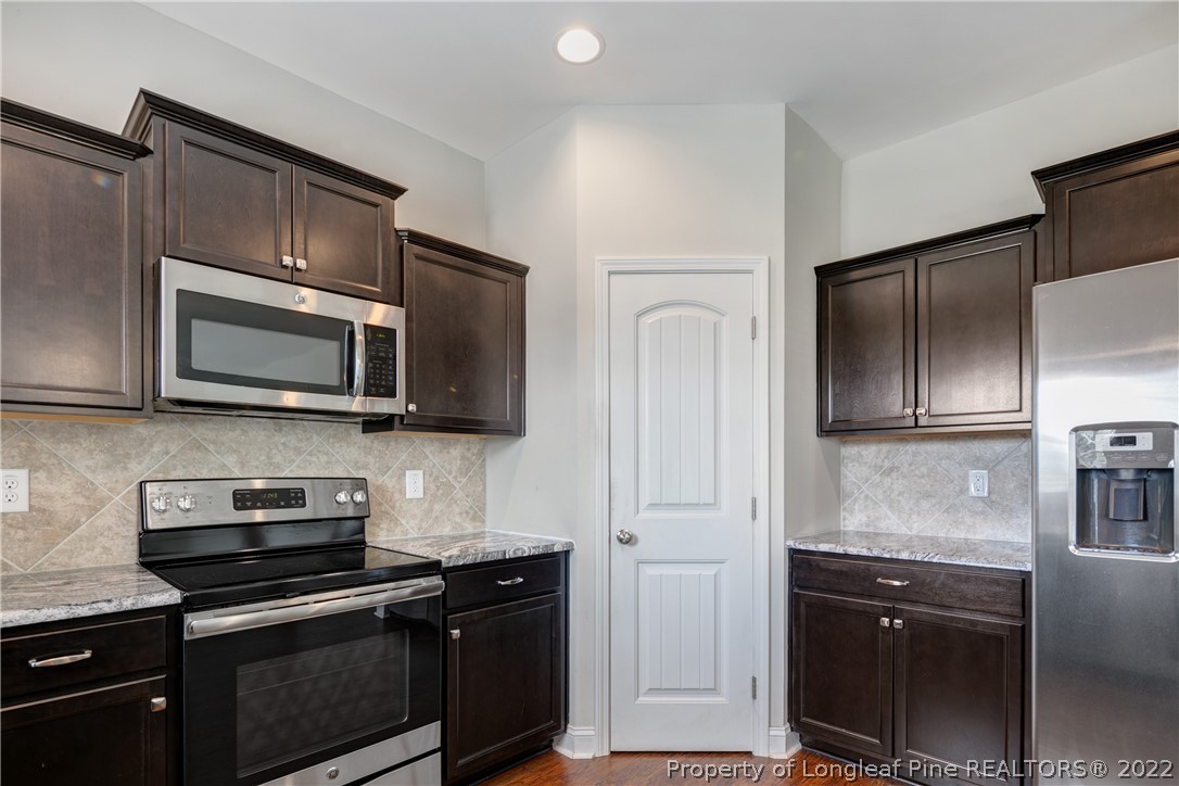 3700 Thrower Road Hope Mills, NC 28348 - Photo 13 of 37 a kitchen with stainless steel appliances granite countertop a stove microwave and refrigerator