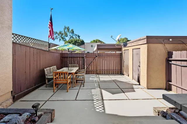 a patio with glass top table and chairs
