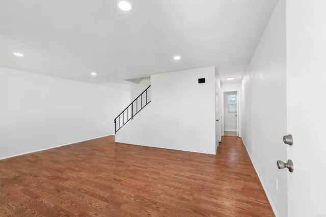 a view of empty room with wooden floor and window