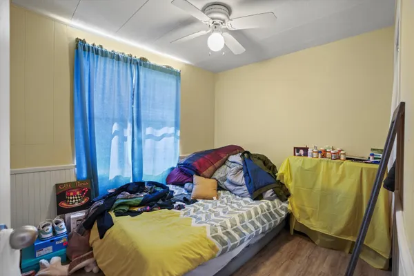a bedroom with a bed and wooden floor