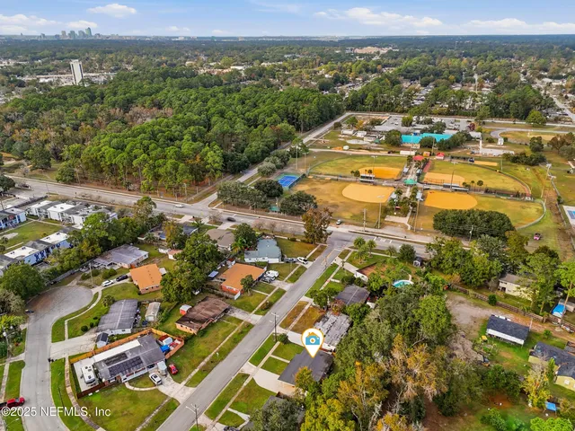 an aerial view of residential houses with outdoor space and trees